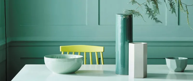 Ambiance Little Greene : table et objets devant un mur vert