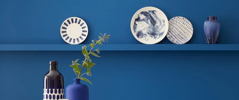 Ambiance Little Greene : objets décoratifs devant un mur bleu